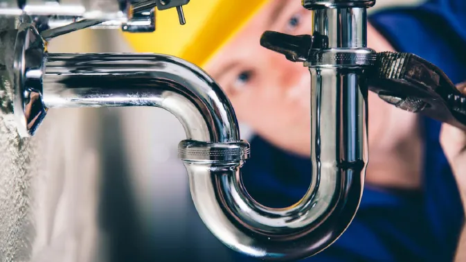 Close-up of a chrome P-trap being tightened